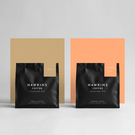 A bag of Hawkins Coffee Milan and a bag of Colombia side by side on light grey